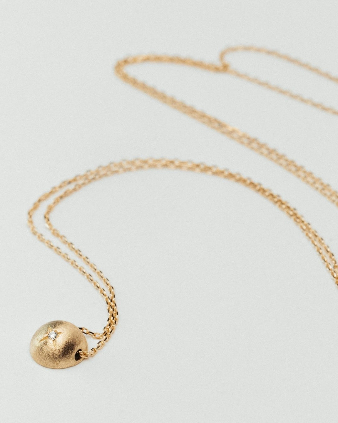 Yellow gold diamond globe necklace