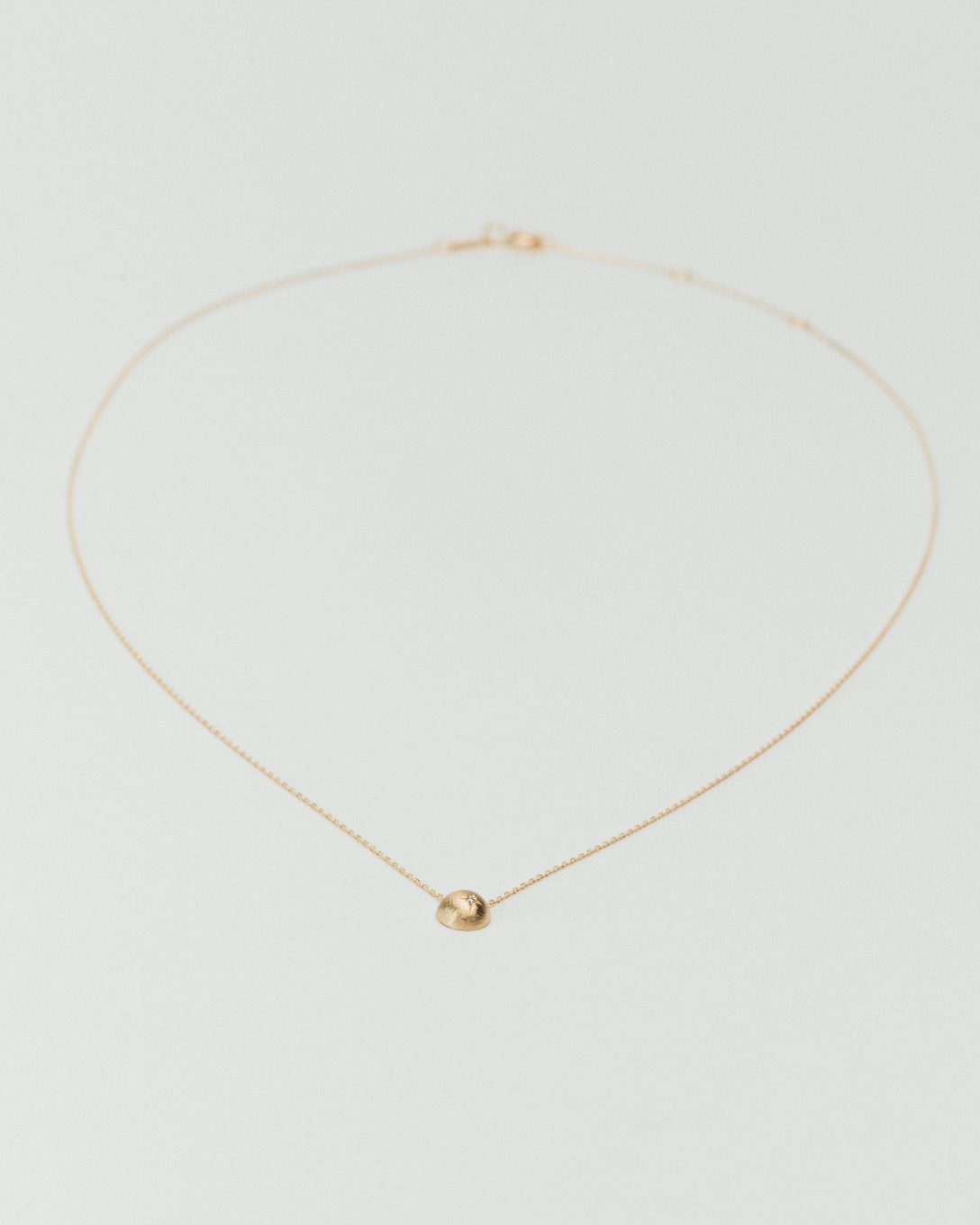 Yellow gold diamond globe necklace