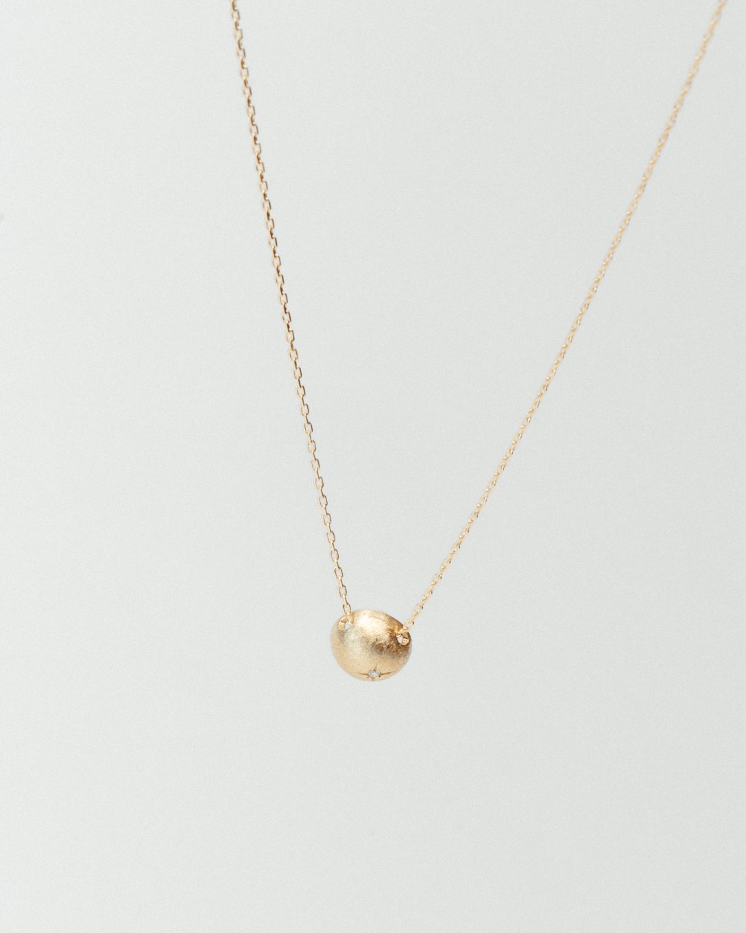 Yellow gold diamond globe necklace